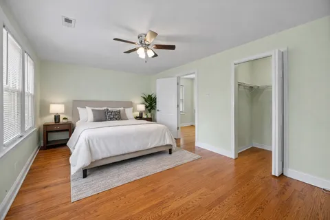 a bedroom with a bed and wooden floor