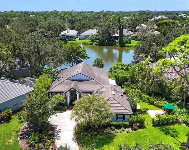 an aerial view of a house with a garden and lake view