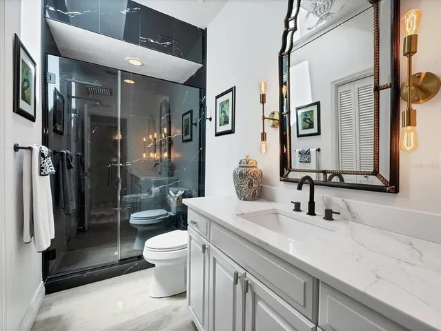 a bathroom with a double vanity sink toilet and shower