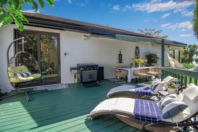 a view of a patio with table and chairs with wooden floor and fence