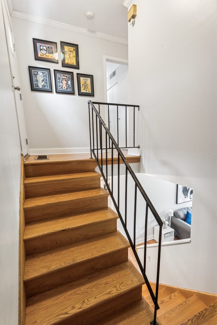 429 West Grant Place, Unit D Chicago, IL 60614 - Photo 12 of 20 a view of staircase with lots of frames on wall and wooden floor