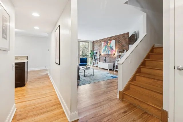 a view of a hallway with wooden floor and staircase