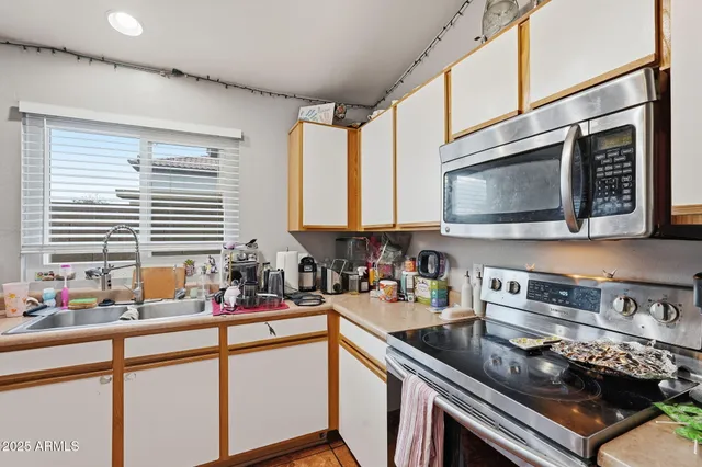 a kitchen with stainless steel appliances a sink a stove and a microwave
