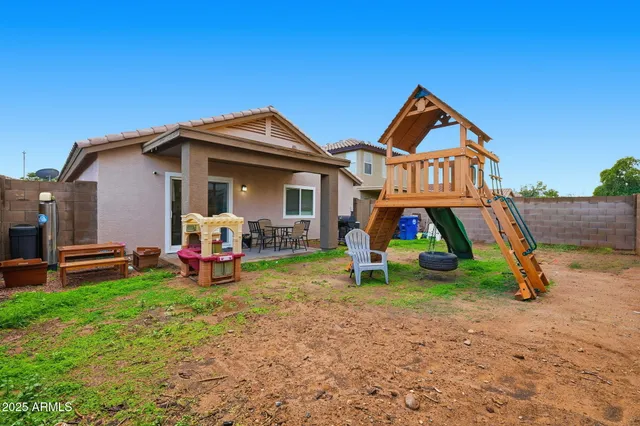 a view of a house with a yard and lawn chairs
