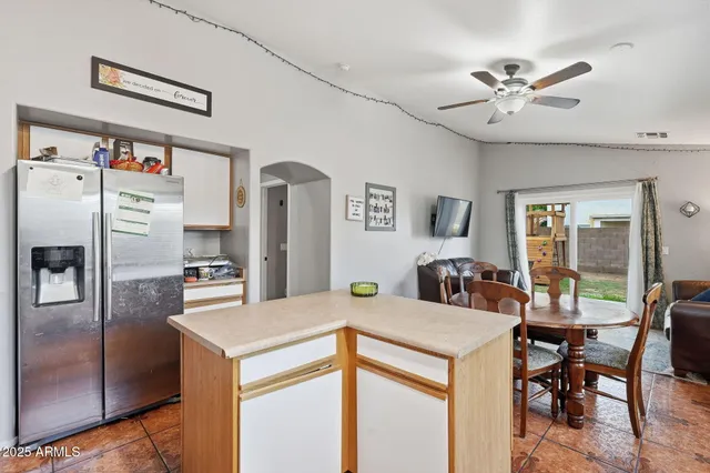a view of a kitchen with refrigerator and workspace