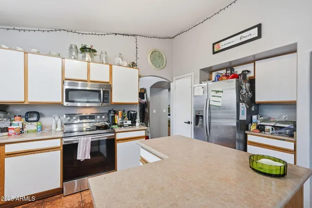 a kitchen with stainless steel appliances granite countertop a lot of cabinets and refrigerator