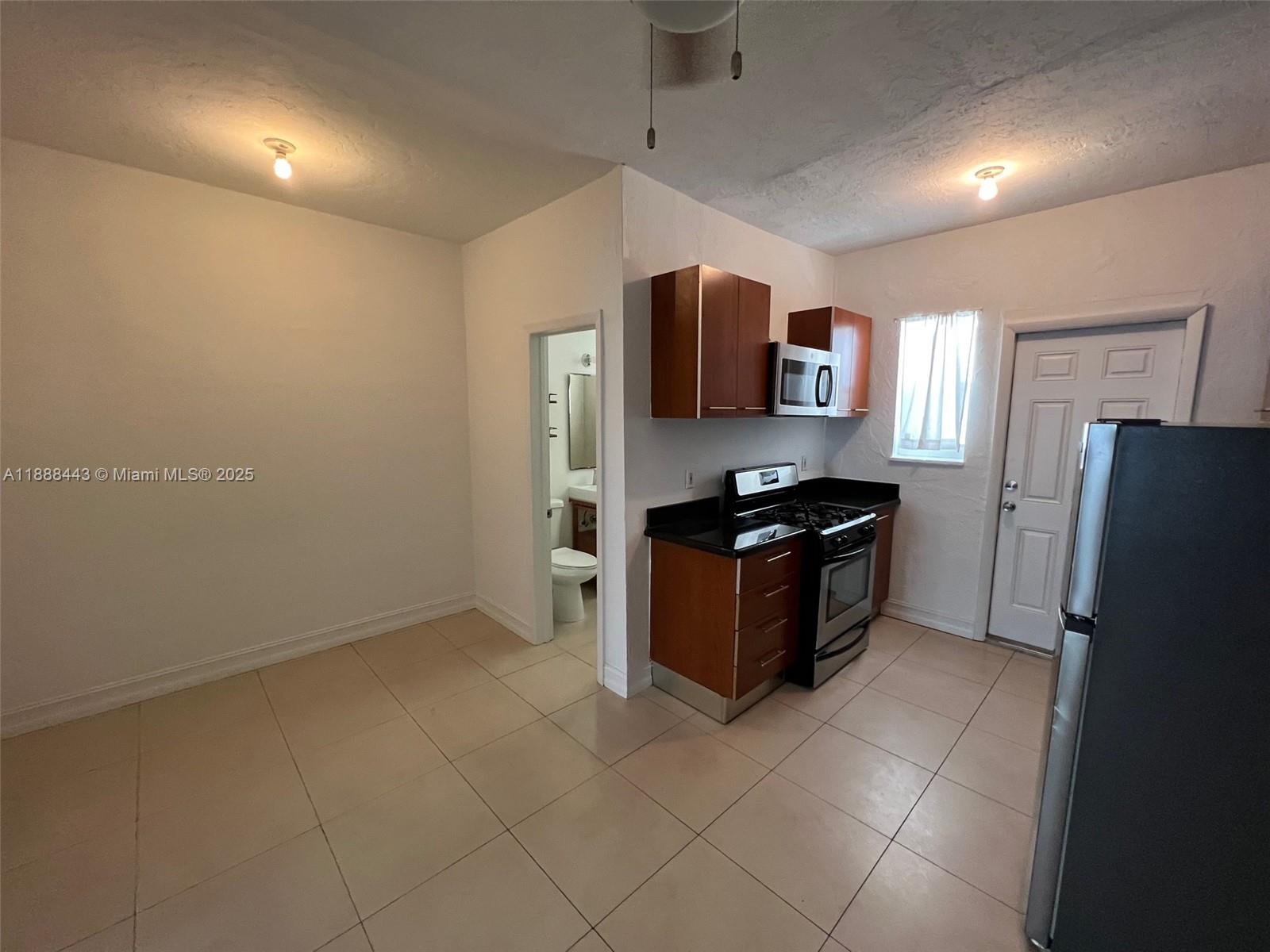 500 14th Street, Unit 105 Miami Beach, FL 33139 - Photo 2 of 10 a kitchen with stainless steel appliances a refrigerator and a stove top oven