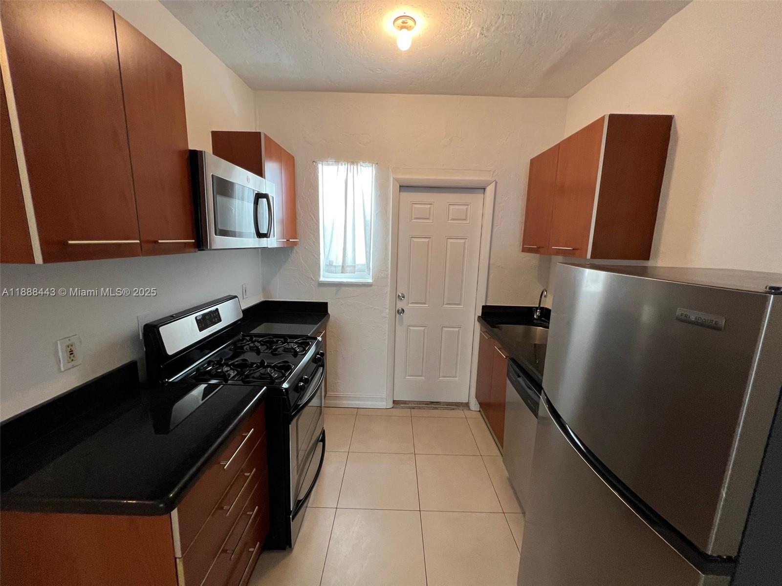 500 14th Street, Unit 105 Miami Beach, FL 33139 - Photo 3 of 10 a kitchen with a refrigerator stove and microwave