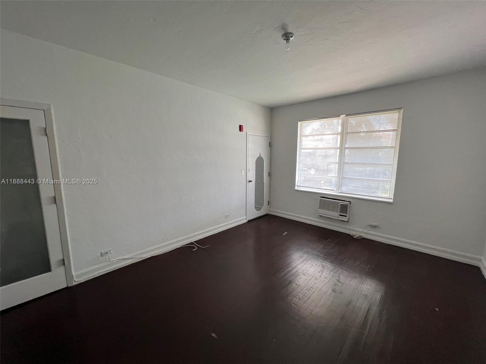 500 14th Street, Unit 105 Miami Beach, FL 33139 - Photo 7 of 10 an empty room with wooden floor and windows