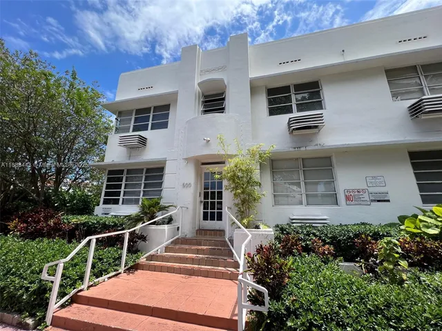 a front view of a house with plants