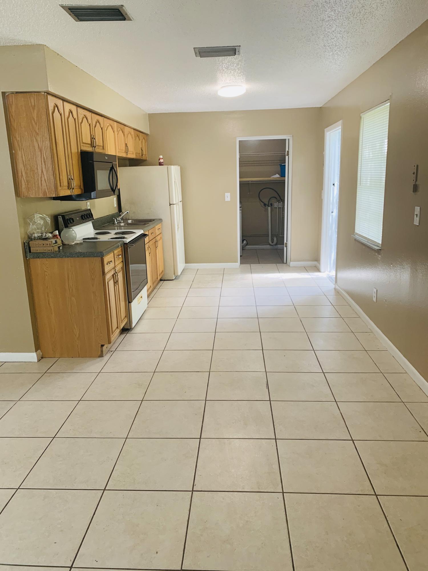 3370 Northwest 40th Drive Okeechobee, FL 34972 - Photo 11 of 14 a kitchen with granite countertop a stove a sink and a refrigerator