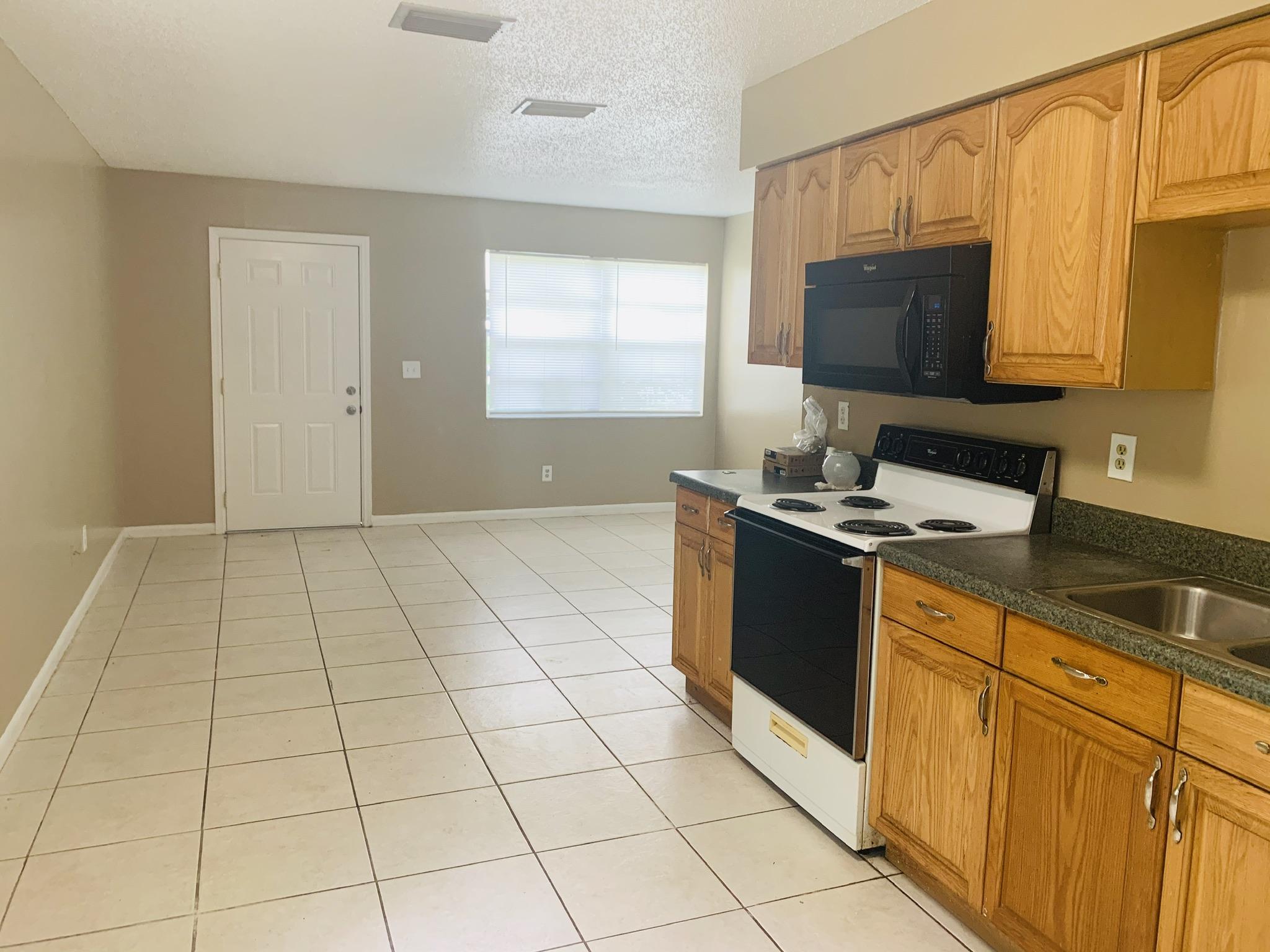 3370 Northwest 40th Drive Okeechobee, FL 34972 - Photo 14 of 14 a kitchen with stainless steel appliances a sink stove and microwave
