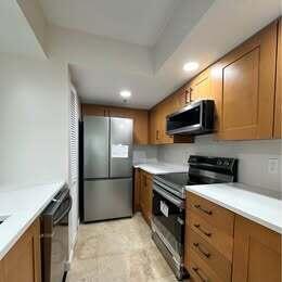 3143 Clint Moore Road, Unit 107 Boca Raton, FL 33496 - Photo 4 of 28 a kitchen with stainless steel appliances granite countertop a refrigerator a stove a sink and a microwave