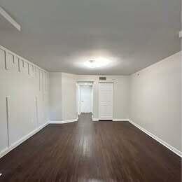 3143 Clint Moore Road, Unit 107 Boca Raton, FL 33496 - Photo 7 of 28 a view of an empty room with wooden floor