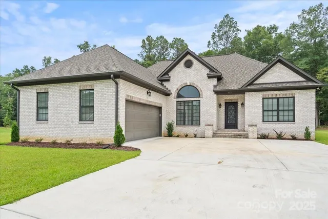 a view of a white house with a yard and large windows