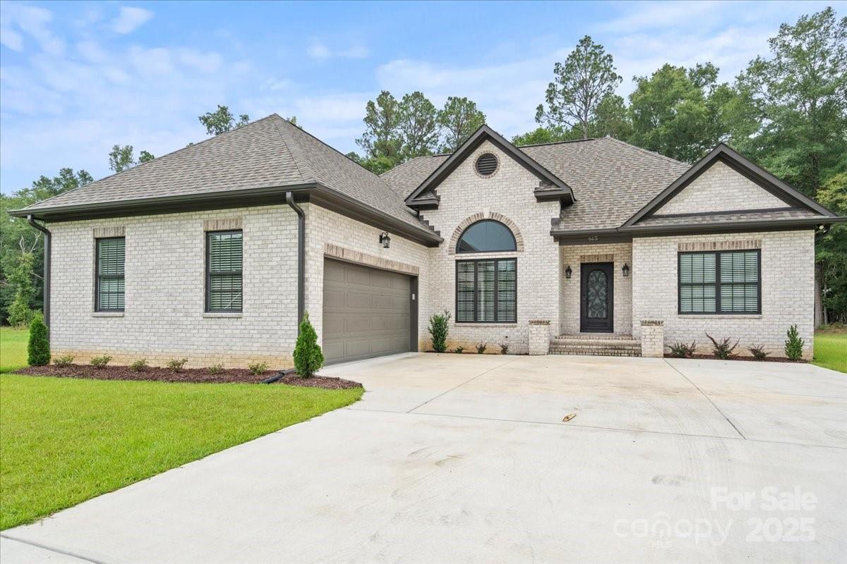 a view of a white house with a yard and large windows