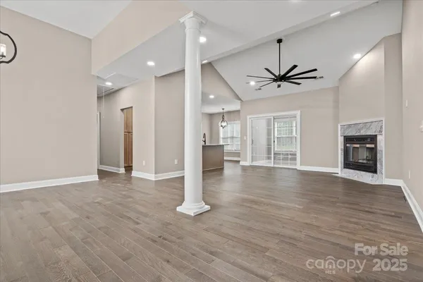 an empty room with wooden floor and a fireplace