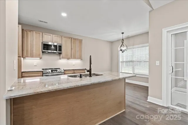 a kitchen with granite countertop a sink a counter top space appliances and cabinets