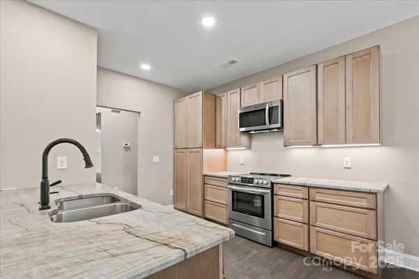 a kitchen with granite countertop a stove and a sink
