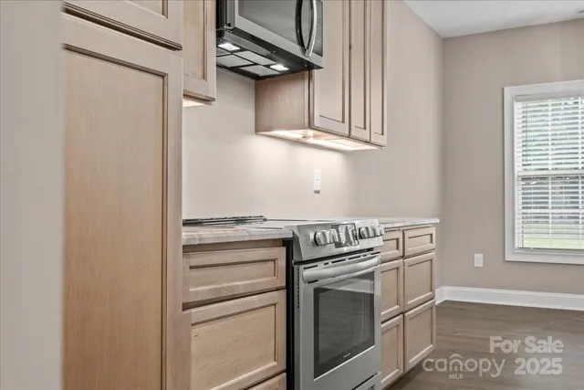 a kitchen with stainless steel appliances granite countertop a stove and a microwave