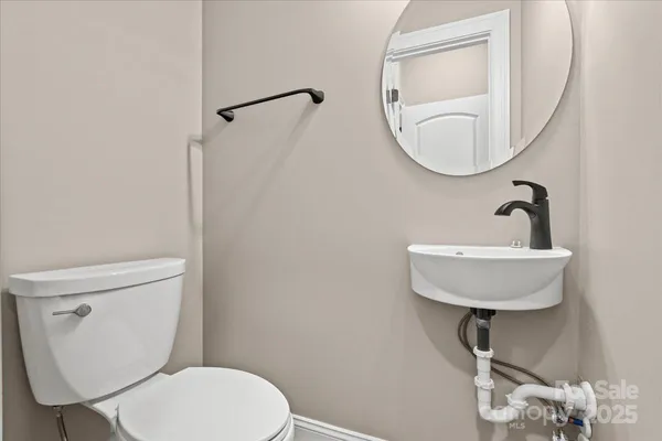 a bathroom with a toilet a sink and mirror