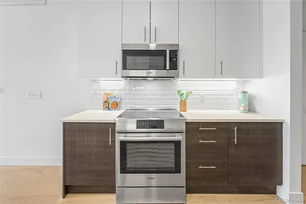 a kitchen with stainless steel appliances granite countertop a stove and a microwave
