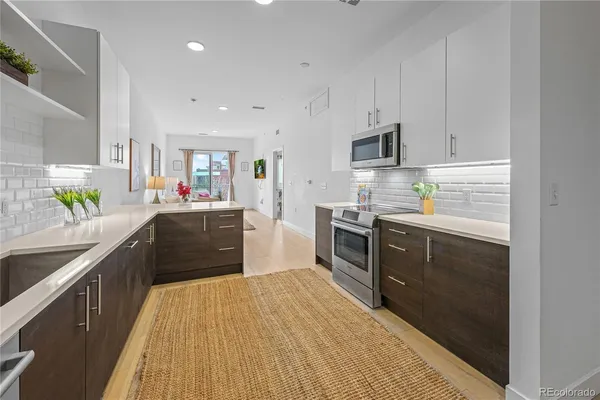 a kitchen with stainless steel appliances granite countertop a stove cabinets and wooden floor