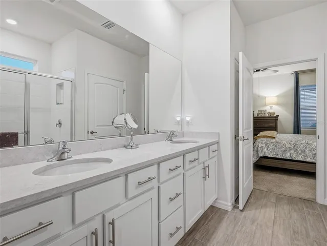 a hallway with painting on the wall and a potted plant