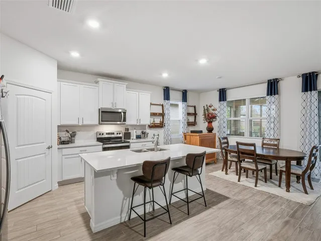 a kitchen that has a sink cabinets and refrigerator