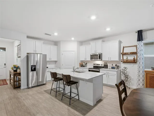a kitchen with white cabinets stainless steel appliances and a sink