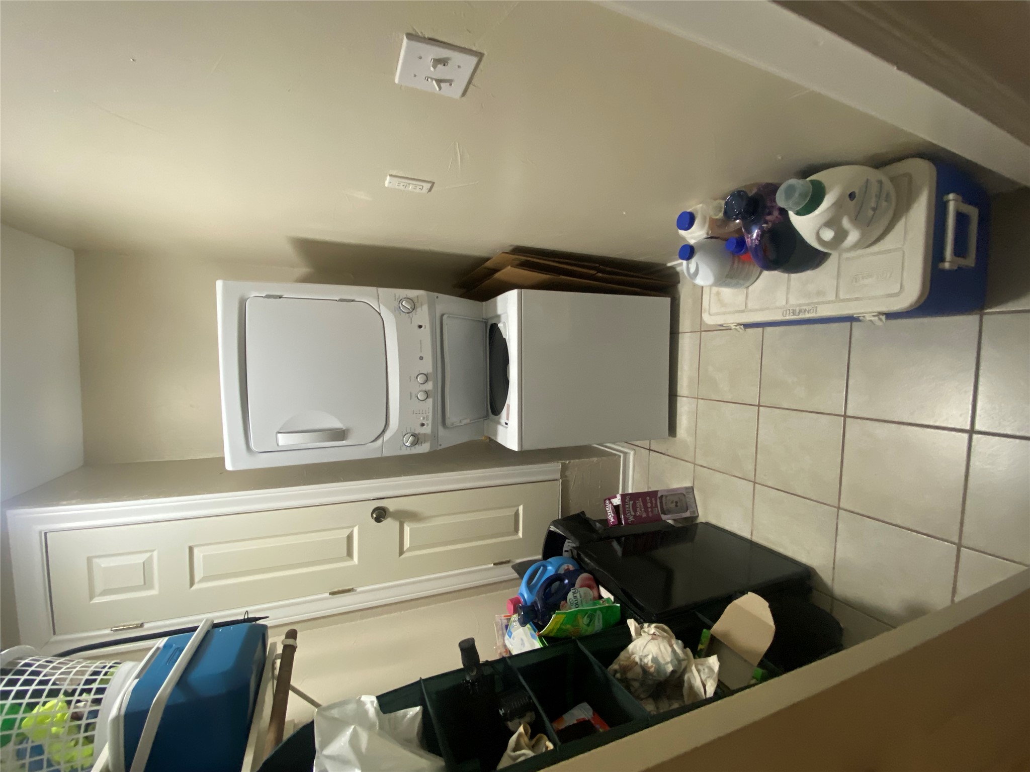 3010 Fruth Street, Unit A Austin, TX 78705 - Photo 16 of 39 Compact laundry area featuring a stacked washer and dryer unit, neutral tone walls, and square tile flooring