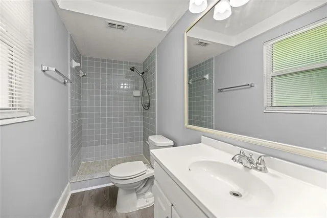 a bathroom with a sink a toilet and shower