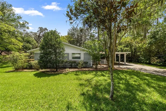 a view of a house with a backyard and sitting area
