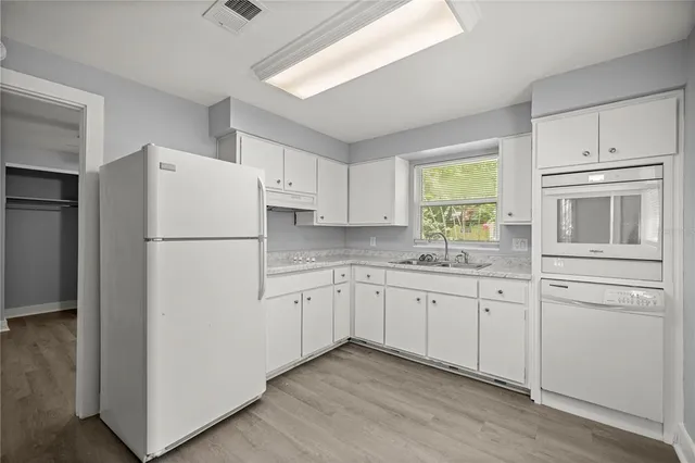 a kitchen with appliances a sink and a refrigerator