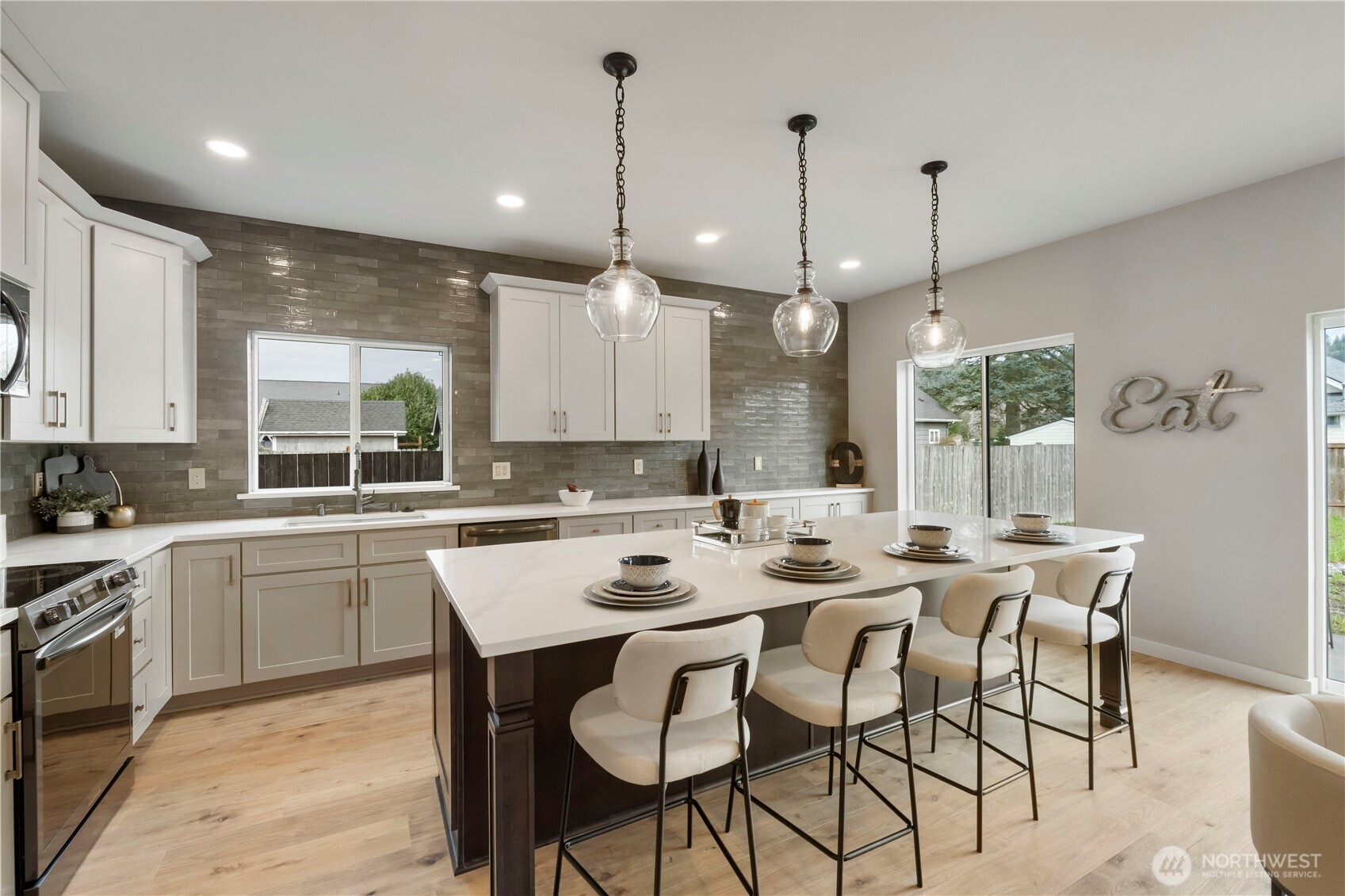 528 Harman Way South Orting, WA 98360 - Photo 9 of 30 a kitchen with a dining table chairs and white cabinets