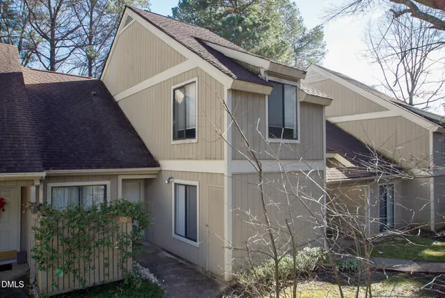 a view of a white house next to a yard