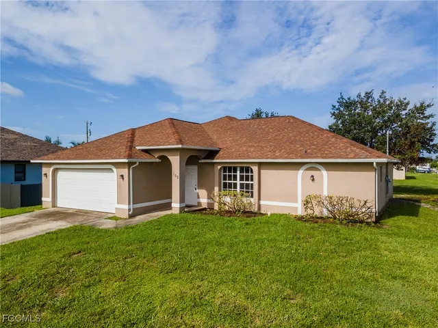 a front view of house with yard and green space