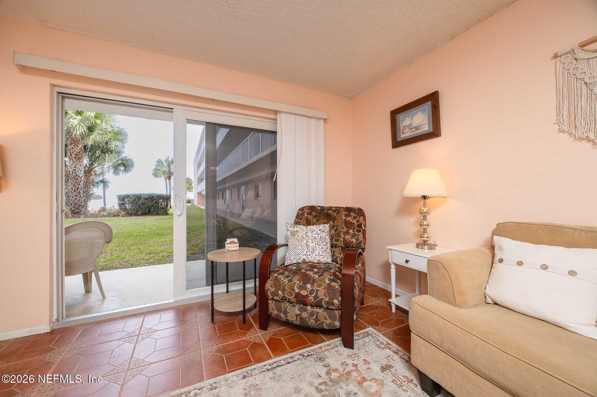 4 Ocean Trace Road, Unit 122 St. Augustine Beach, FL 32080 - Photo 33 of 48 a living room with furniture and a large window