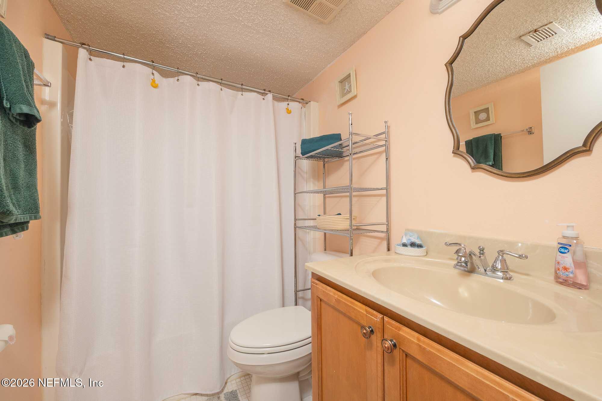 4 Ocean Trace Road, Unit 122 St. Augustine Beach, FL 32080 - Photo 44 of 48 a bathroom with a sink a toilet and a mirror