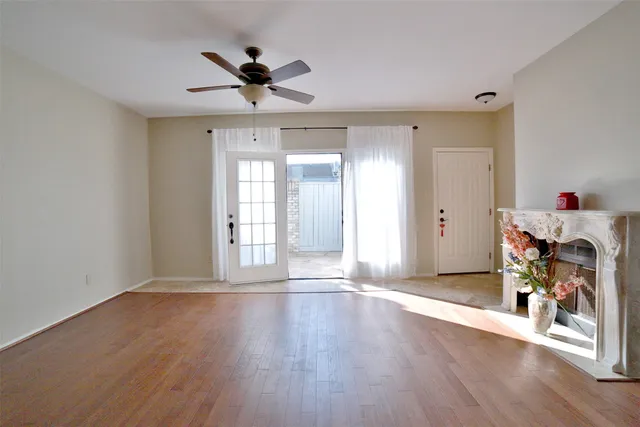 a view of a livingroom with wooden floor and a ceiling fan