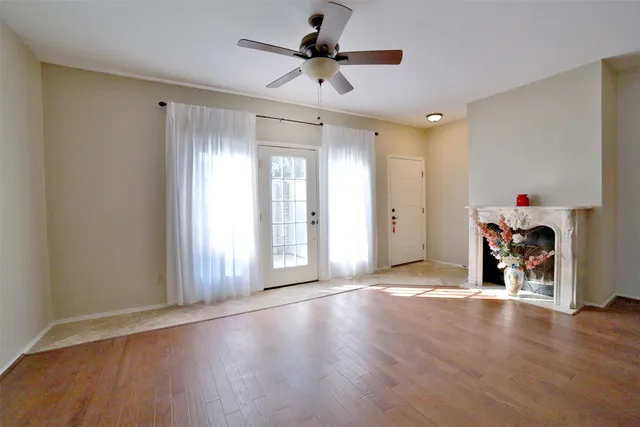 a view of a livingroom with wooden floor and a ceiling fan