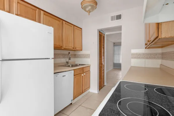 a kitchen with a sink a stove and a refrigerator