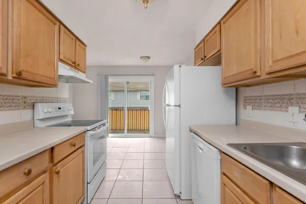 a kitchen with a sink dishwasher a stove and a refrigerator with cabinets