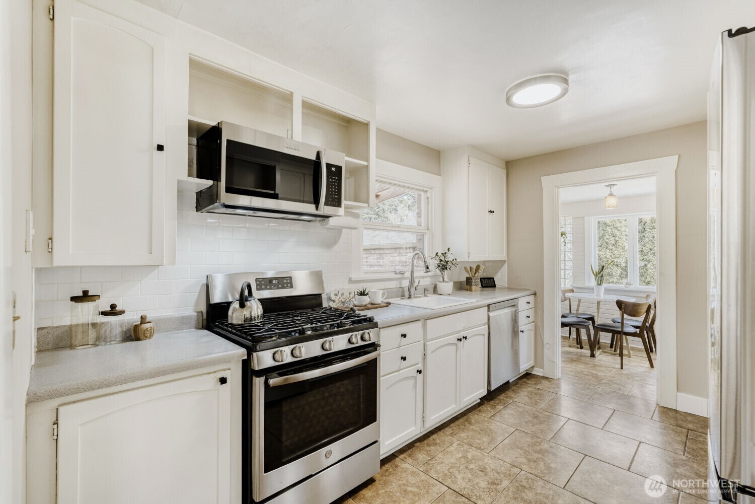 348 Northeast 57th Street Seattle, WA 98105 - Photo 9 of 28 a kitchen with stainless steel appliances a stove microwave and cabinets