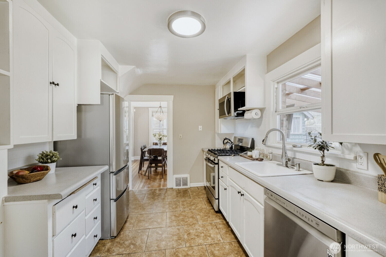 348 Northeast 57th Street Seattle, WA 98105 - Photo 10 of 28 a kitchen with sink a stove and cabinets