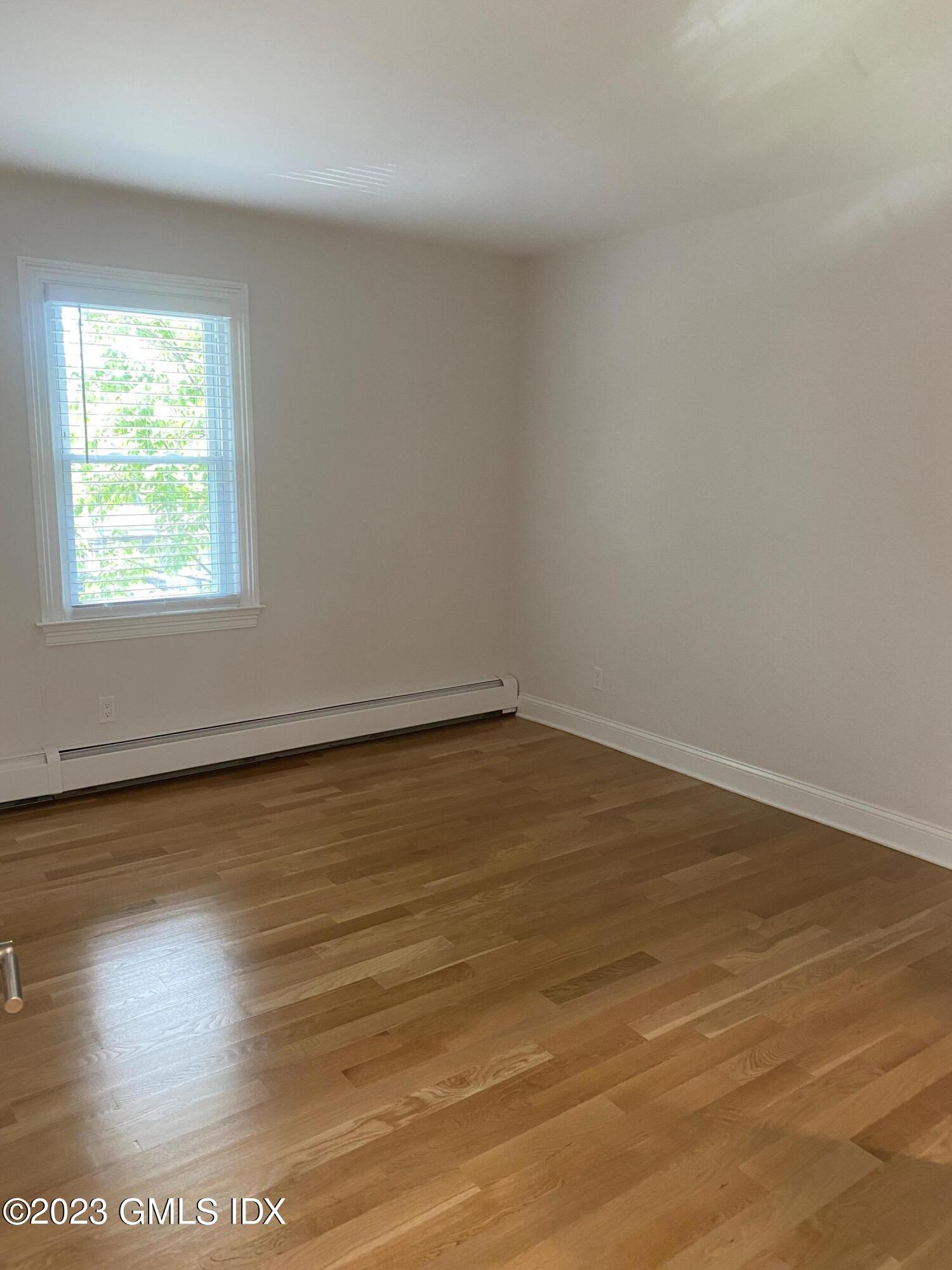 36 Arch Street, Unit 2A Greenwich, CT 06830 - Photo 6 of 9 an empty room with wooden floor and windows