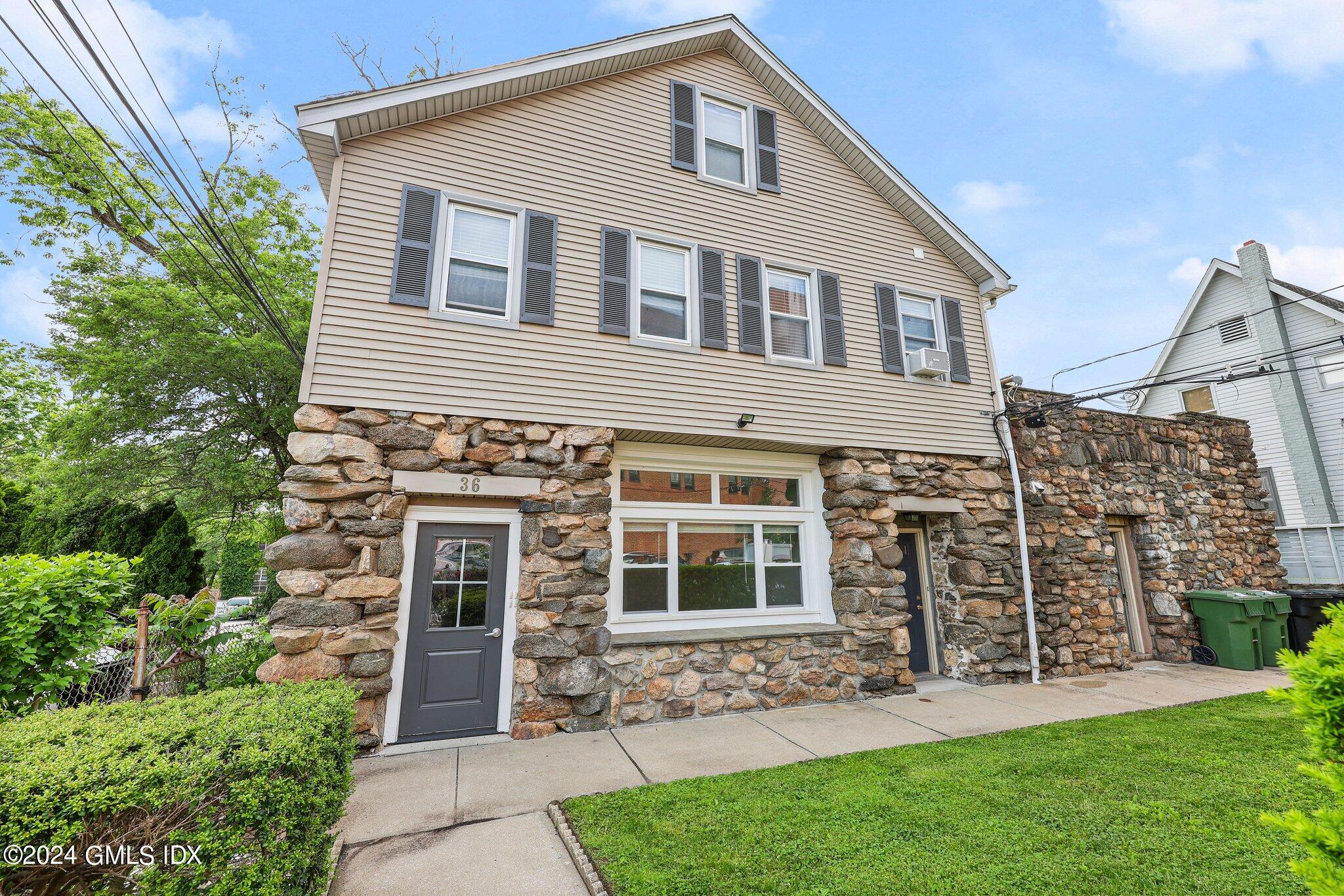 36 Arch Street, Unit 2A Greenwich, CT 06830 - Photo 9 of 9 a front view of a house with a garden and plants