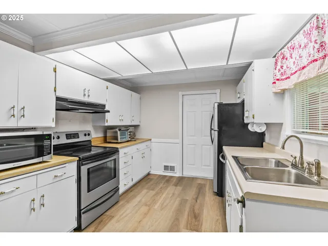 a kitchen with granite countertop a sink stainless steel appliances and cabinets
