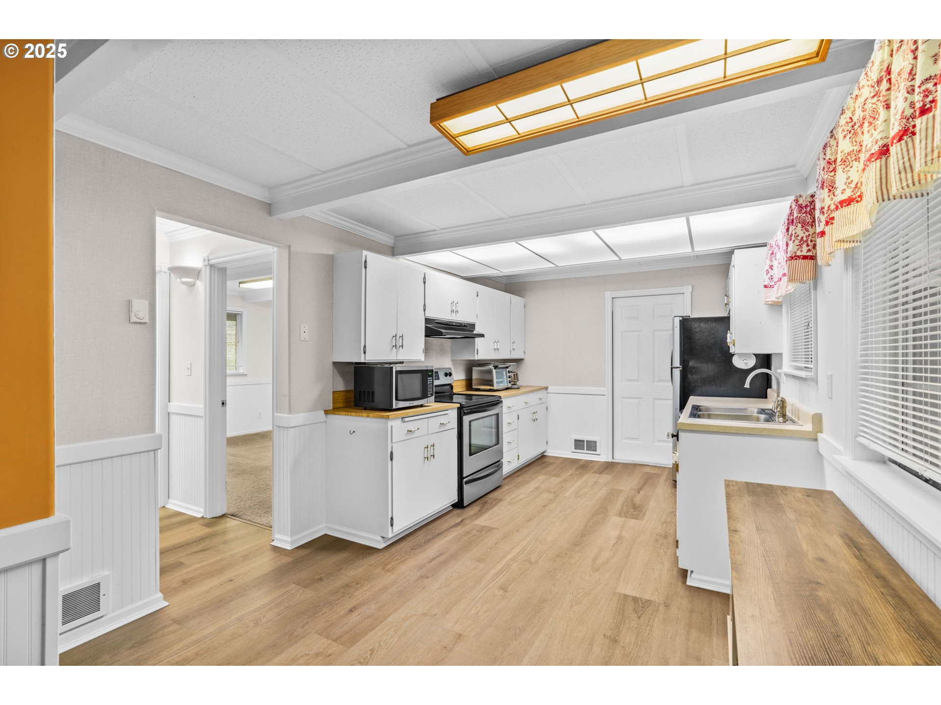 5213 Hilltop Drive Florence, OR 97439 - Photo 9 of 32 a living room with stainless steel appliances kitchen island granite countertop a refrigerator a stove a sink dishwasher and white cabinets with wooden floor