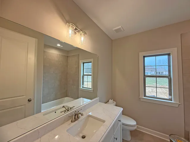 a bathroom with a toilet sink and mirror